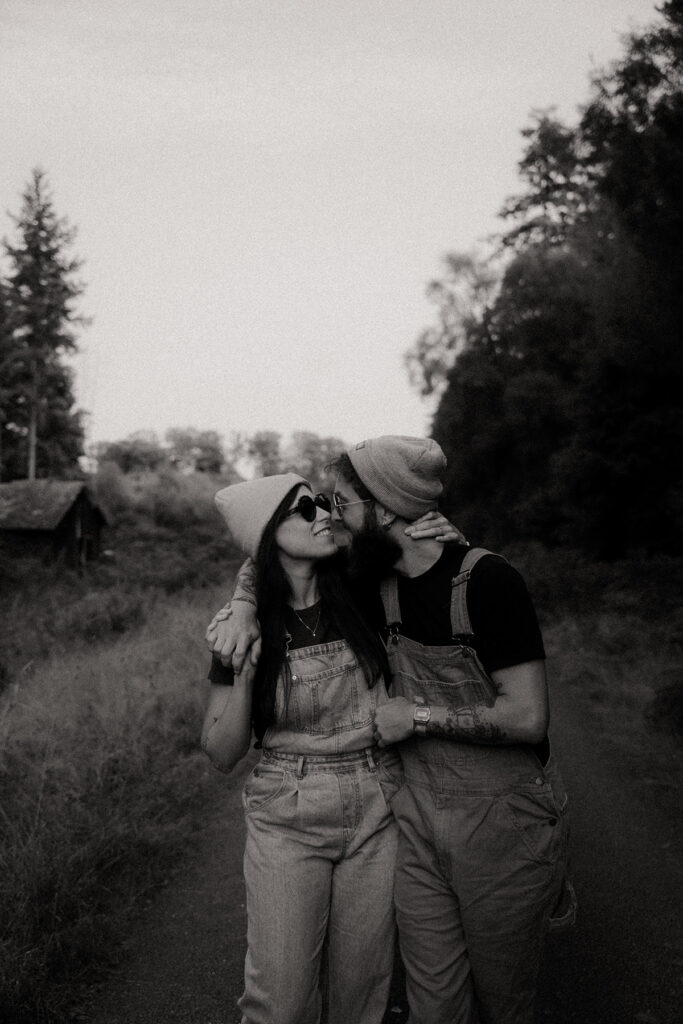 Caroline et Fabien enlacés, marchant le long d'un sentier en forêt pendant une séance engagement. Photo en noir et blanc.