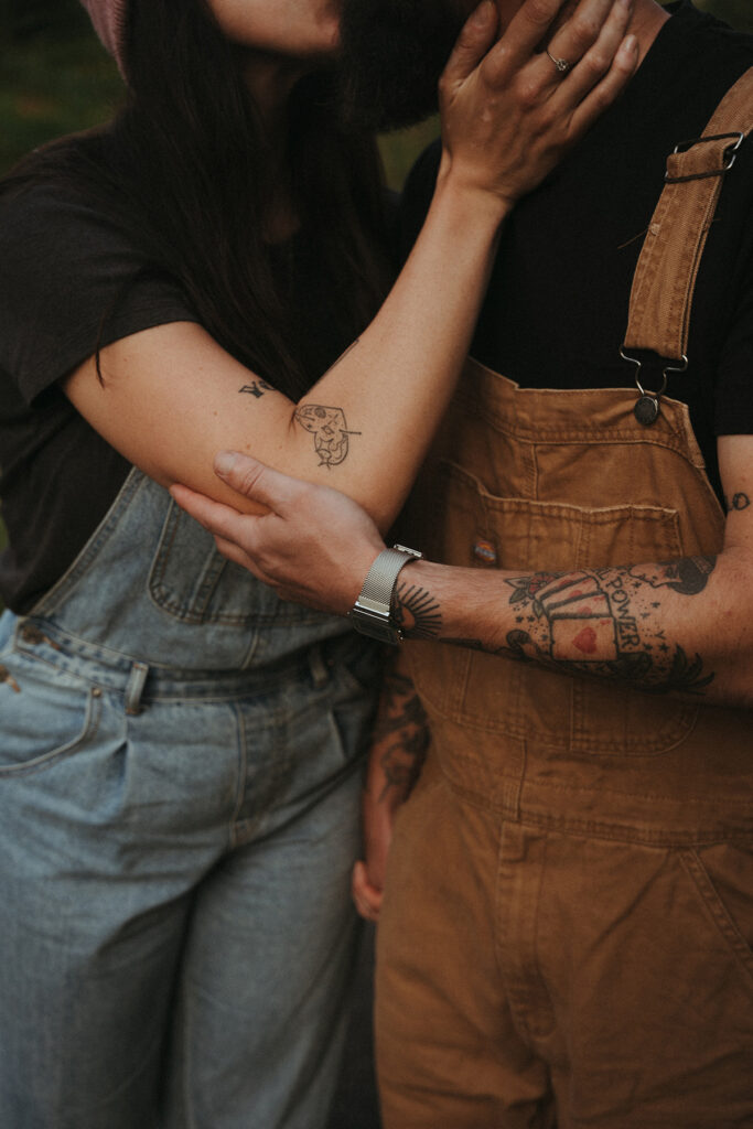 Zoom sur les tatouages de caroline et fabien, s'embrassant pendant une séance photo d'engagement.